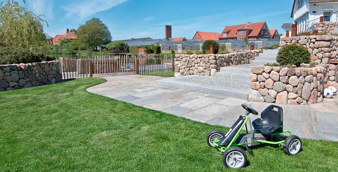 Gestaltung und Konzeption eines Gartens für ein Einfamilienhaus: Rollrasen, Terrasse, Mauern und Treppen